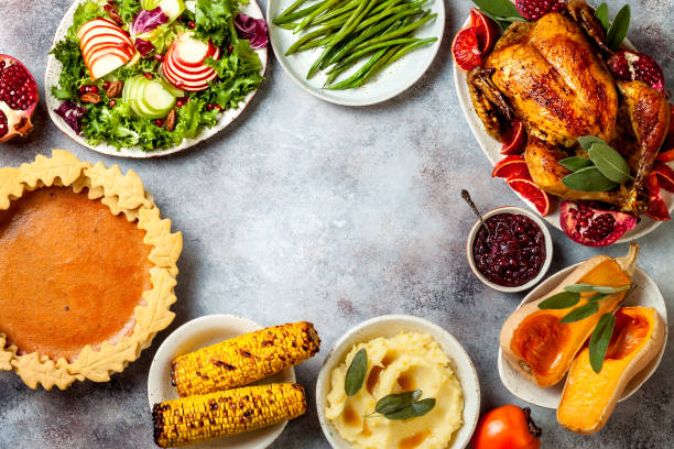 istock Thanksgiving dinner table with roasted whole chicken or turkey, green beans, mashed potatoes, cranberry sauce and grilled autumn vegetables. Top view, overhead. 1169350988