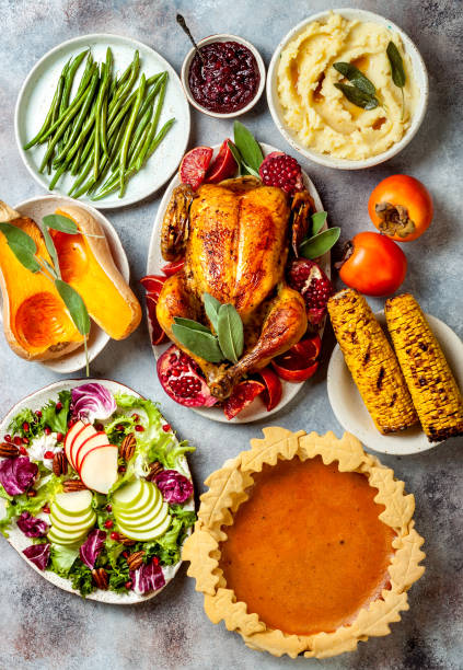 istock Thanksgiving dinner table with roasted whole chicken or turkey, green beans, mashed potatoes, cranberry sauce and grilled autumn vegetables. Top view, overhead. 1169350989