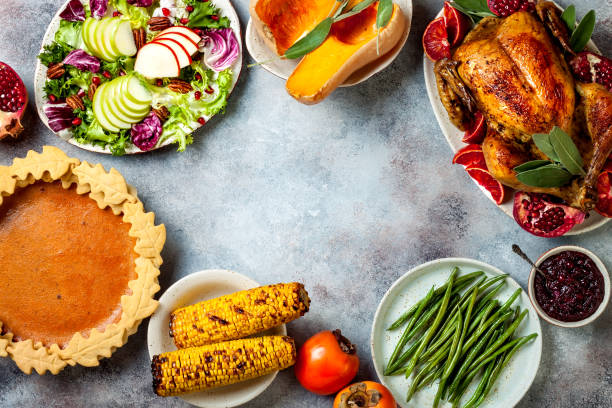 istock Thanksgiving dinner table with roasted whole chicken or turkey, green beans, mashed potatoes, cranberry sauce and grilled autumn vegetables. Top view, overhead. 1169350994