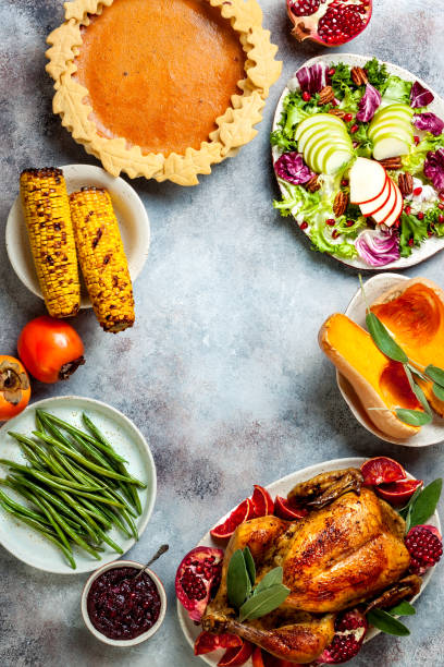 istock Thanksgiving dinner table with roasted whole chicken or turkey, green beans, mashed potatoes, cranberry sauce and grilled autumn vegetables. Top view, overhead. 1169350996