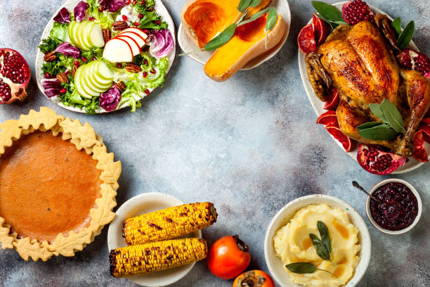 istock Thanksgiving dinner table with roasted whole chicken or turkey, green beans, mashed potatoes, cranberry sauce and grilled autumn vegetables. Top view, overhead. 1169351059
