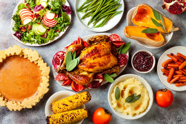 istock Thanksgiving dinner table with roasted whole chicken or turkey, green beans, mashed potatoes, cranberry sauce and grilled autumn vegetables. Top view, overhead. 1169351060