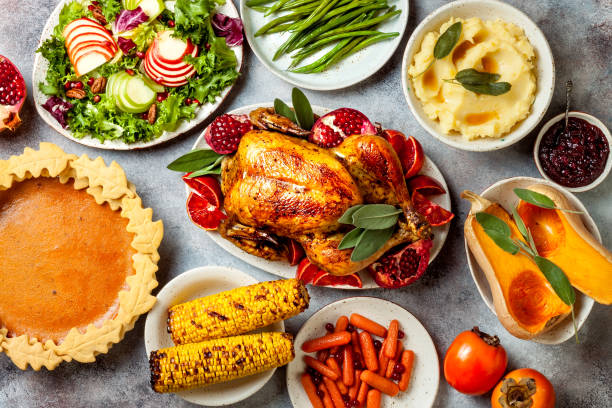 istock Thanksgiving dinner table with roasted whole chicken or turkey, green beans, mashed potatoes, cranberry sauce and grilled autumn vegetables. Top view, overhead. 1169351318