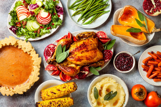 istock Thanksgiving dinner table with roasted whole chicken or turkey, green beans, mashed potatoes, cranberry sauce and grilled autumn vegetables. Top view, overhead. 1169351324