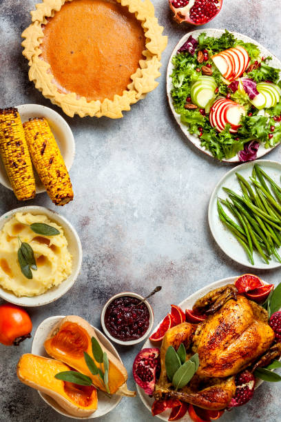 istock Thanksgiving dinner table with roasted whole chicken or turkey, green beans, mashed potatoes, cranberry sauce and grilled autumn vegetables. Top view, overhead. 1169351669
