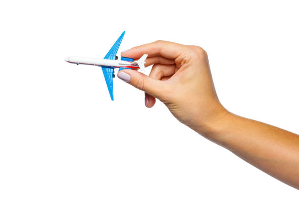 istock hand holding airplane toy model isolated on white background 1169351959