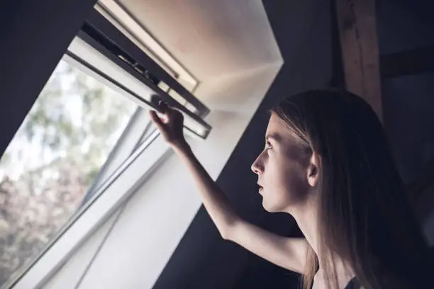 teenage girl opening a window