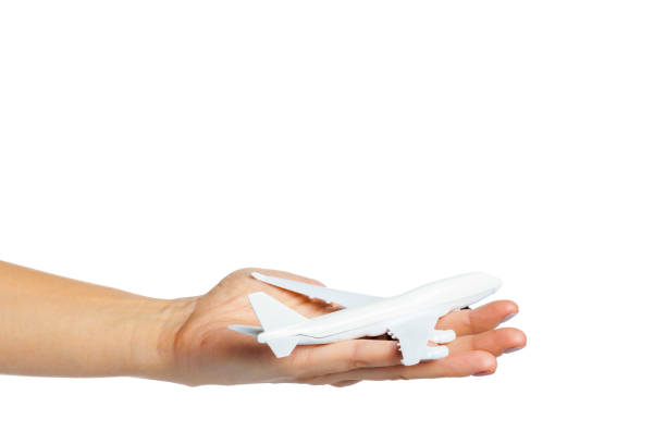 istock hand holding airplane toy model isolated on white background 1169352063