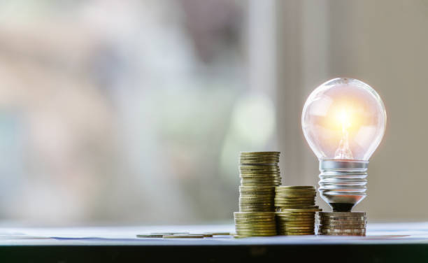 istock Coins and light bulb put on the table for saving money,energy concept. 1169355732