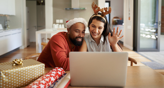 Shot of a happy young couple using a laptop during the Christmas holidays at home