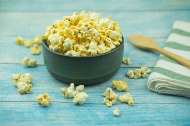 istock Popcorn in a bowl against blue wooden background 1169357323