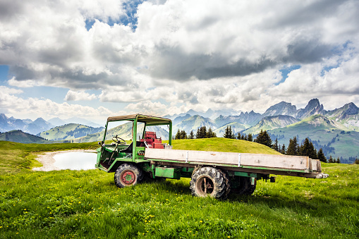 Agricultural vehicle on an alpine pasture in Switzerland, in the background the Fribourg Alps