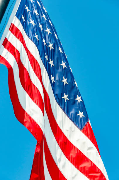istock American Flag Against Blue Sky 1169357688