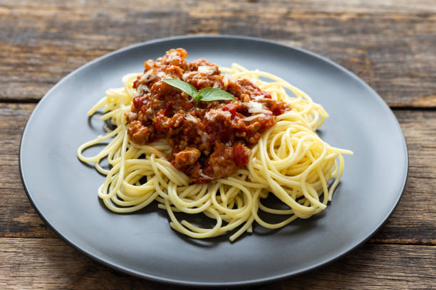 istock Spaghetti on black plate on wooden background. top view 1169358926