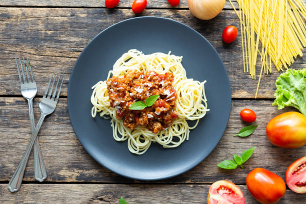 istock Spaghetti on black plate on wooden background. top view 1169358932