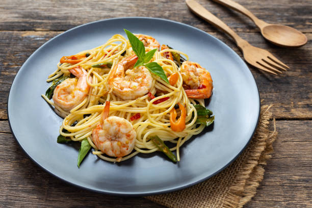 istock Spaghetti on black plate on wooden background. top view 1169358956