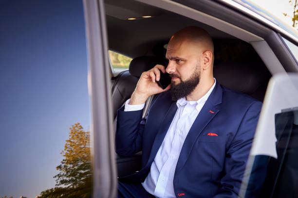 istock Successful young man talking on the phone in a car. 1169360260