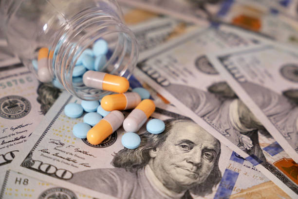 Pills and capsules in a bottle on US dollars bills Concept of health care, pharmaceutical business, drug prices, pharmacy, medicine and economics drugs stock pictures, royalty-free photos & images