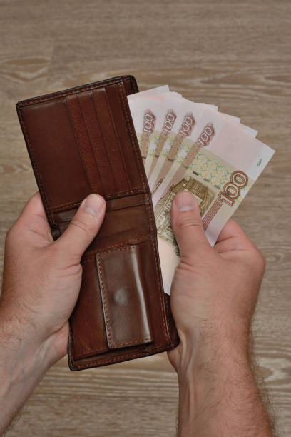 istock A man's hand takes Russian banknotes from his wallet. Close Up 1169362154