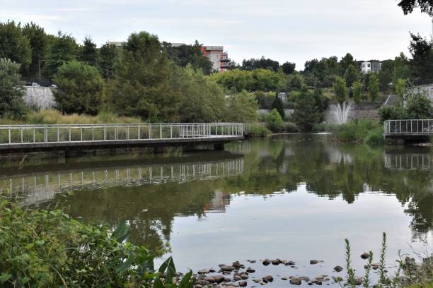 istock Public Park with lake, waterfall and pedestrian walkway 1169365086