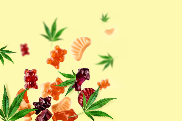 Colored gummies fly along with cannabis leaves. Chewing candies, gummies with CBD oil and THC. Colorful creative background, minimalism. Chewing candies, marmalade with CBD oil and THC. Colored marmalades fly along with cannabis leaves. Colorful creative background, minimalism. gummy candy photos stock pictures, royalty-free photos & images