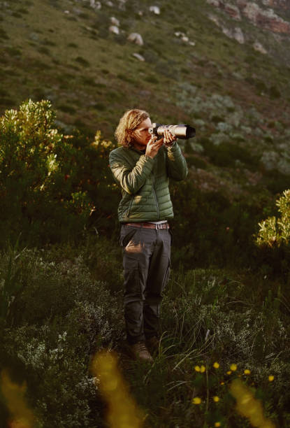 Photographer taking phots on dslr camera in mountains