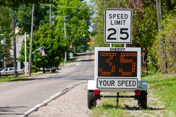 Speeding A sheriff’s radar device measures the speed of cars passing by. speed limit sign stock pictures, royalty-free photos & images