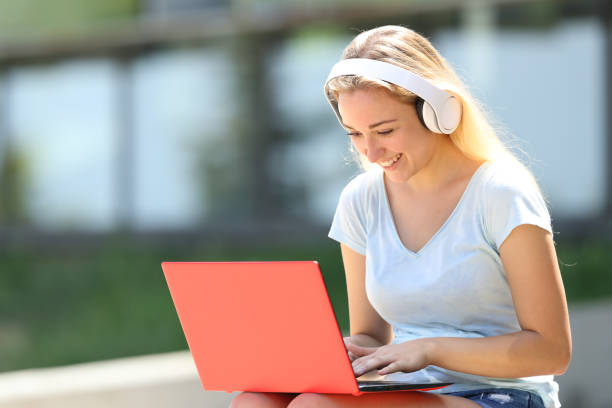 istock Happy teenage student e-learning using laptop and headphones 1169370606