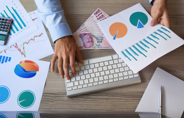istock Financial concepts, a businessman working on office desk with business graphs, computer, calculator and turkish currency 1169370920