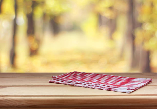 istock empty table with red towel on autumn background. copy space. 1169373289