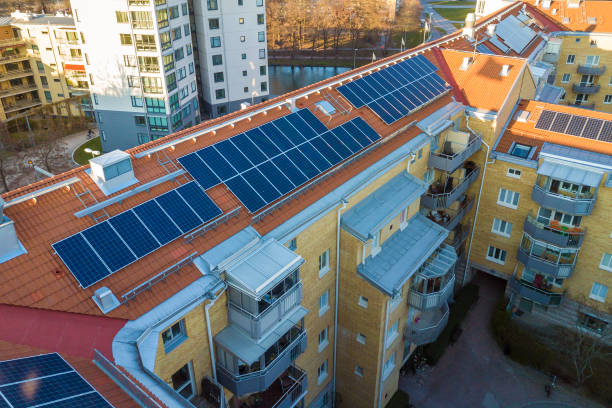 aerial view of solar photo voltaic panels system on apartment building roof. renewable ecological green energy production concept. - voltaic imagens e fotografias de stock