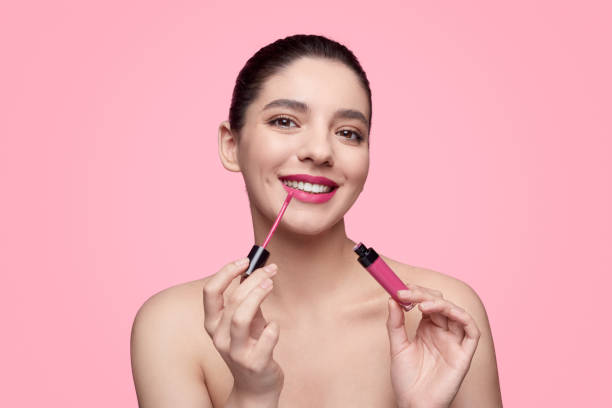 istock Smiling woman rouging lips 1169378232