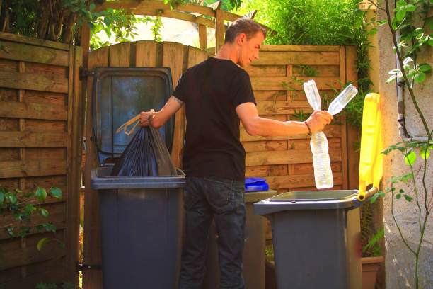 person performing a selective sorting of household waste in recycling bins in his garden. - decisions nature road street imagens e fotografias de stock