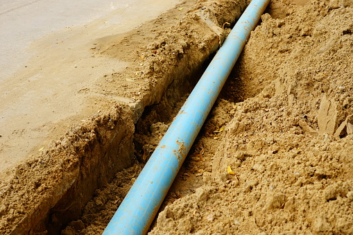 Long blue plastic sewer pipes on road