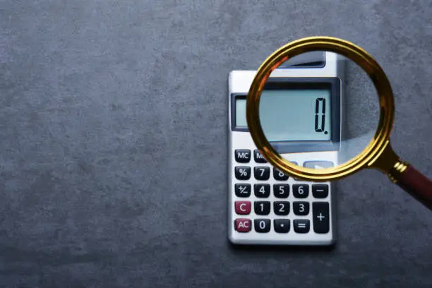Photo of Financal concepts, a calculator showing zero with magnifying glass