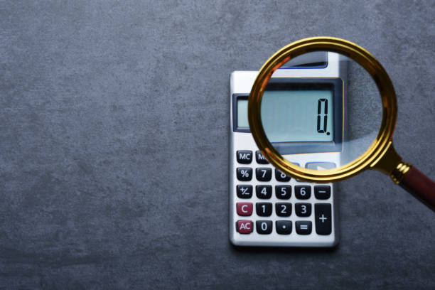 financal concepts, a calculator showing zero with magnifying glass - zero imagens e fotografias de stock
