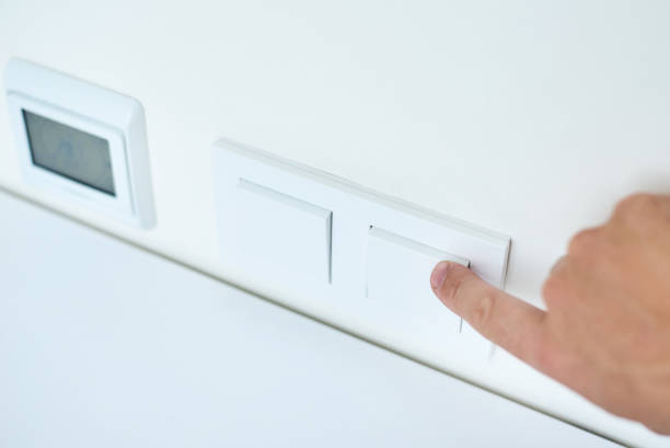 istock Hand is turning on or off on light switch, closeup 1169381264