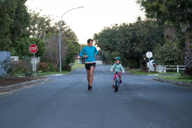 istock Mother runs alongside her daughter on a bicycle 1169381443