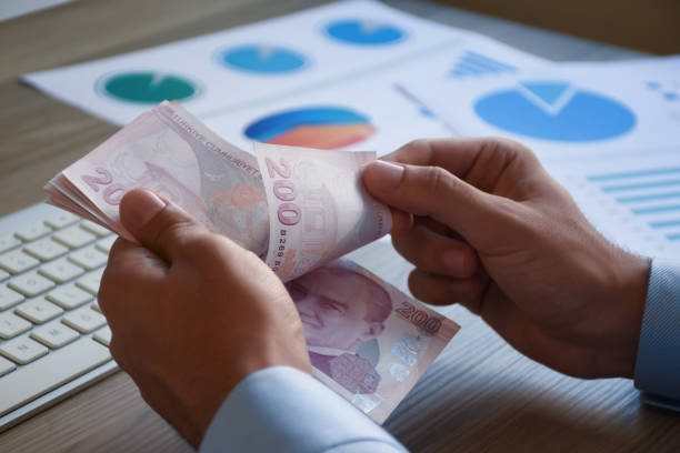 Financial concepts, businessman counting turkish money, two hundered lira on the office desk with business graphs Financial concepts, businessman counting turkish money, two hundered lira on the office desk with business graphs lira sign photos stock pictures, royalty-free photos & images