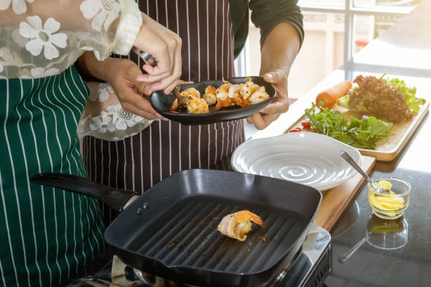 istock Two chefs help fry shrimp in the kitchen. 1169385027
