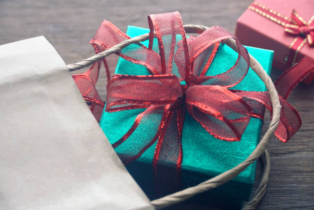 istock Close up green gift box on shopping bag on the table. 1169387742