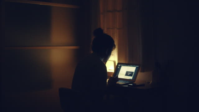 Woman using laptop at night
