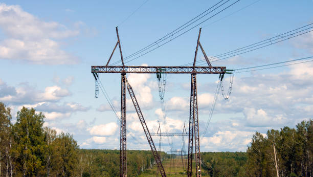 istock A high-voltage power line runs along a clearing among the trees. Sunny day, blue sky with clouds 1169392390