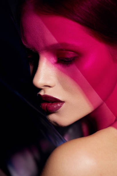 istock Makeup beauty. Woman model with dark lipstick under pink light 1169393018