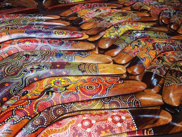 feche acima dos bumerangs de madeira coloridos pintados mão no mercado australiano - indigenous culture aborigine australia australian culture - fotografias e filmes do acervo