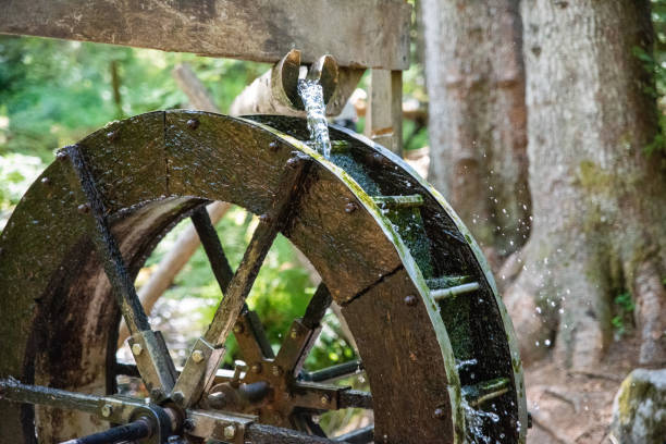 una ruota idraulica nella foresta con aggiunta di sfocatura del movimento. - opificio foto e immagini stock