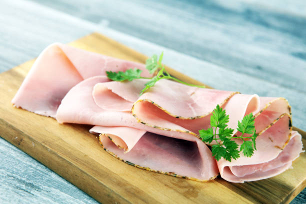 istock Sliced ham with parsley on table. Fresh prosciutto. Pork ham sliced. 1169407053