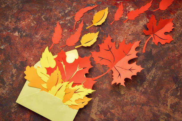 istock Flat lay on dark with red and orange paper leaves in envelope 1169412728