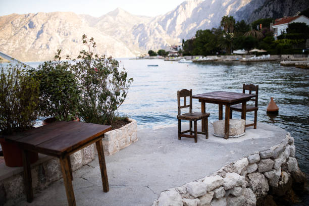 Romantic dinner for two at sunset. Restaurant on the beach with mountain on background