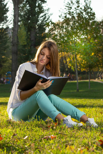 istock Woman relaxing in nature with book 1169416849